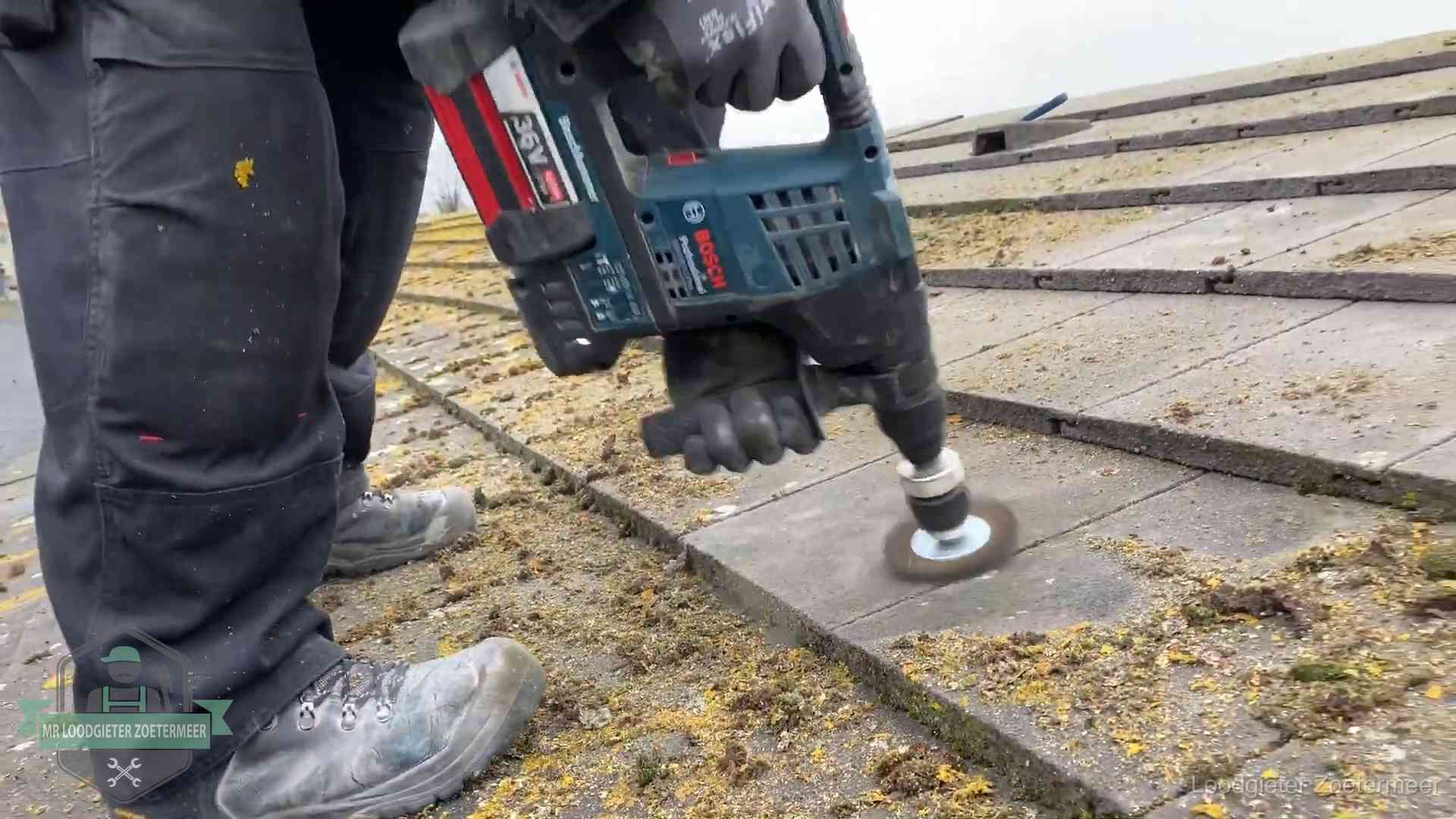 Betonnen dakpannen worden machinaal gereinigd tijdens dakonderhoud in Zoetermeer