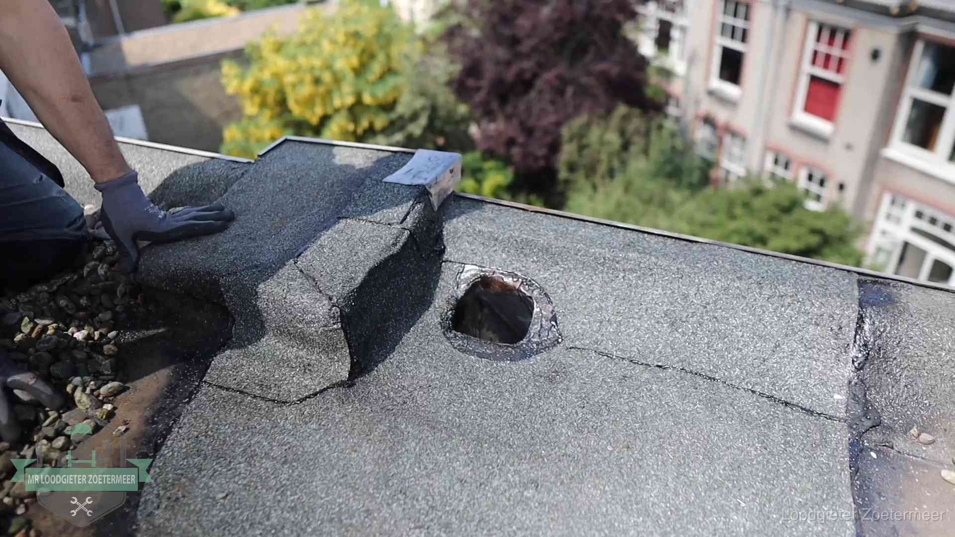 Loodgieter inspecteert een beschadigd bitumen plat dak tijdens een daklekkage-inspectie in Zoetermeer