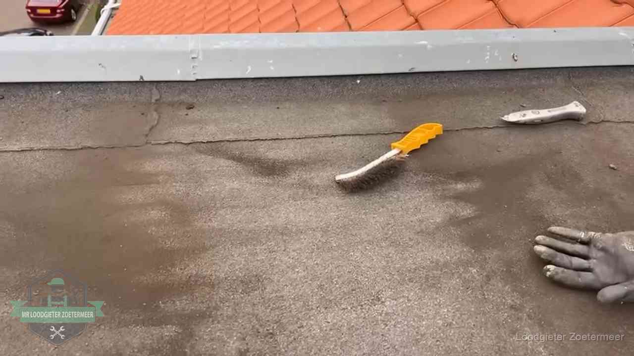 Dakdekker bereidt een bitumen plat dak voor op reparatie bij de daktrim in Zoetermeer
