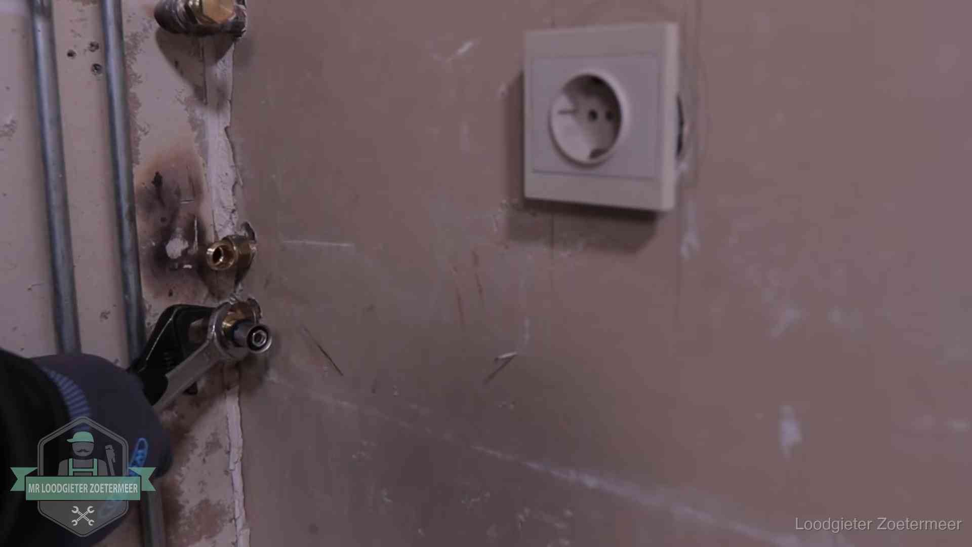 Monteur draait een perskoppeling vast op een leidingaansluiting in Zoetermeer