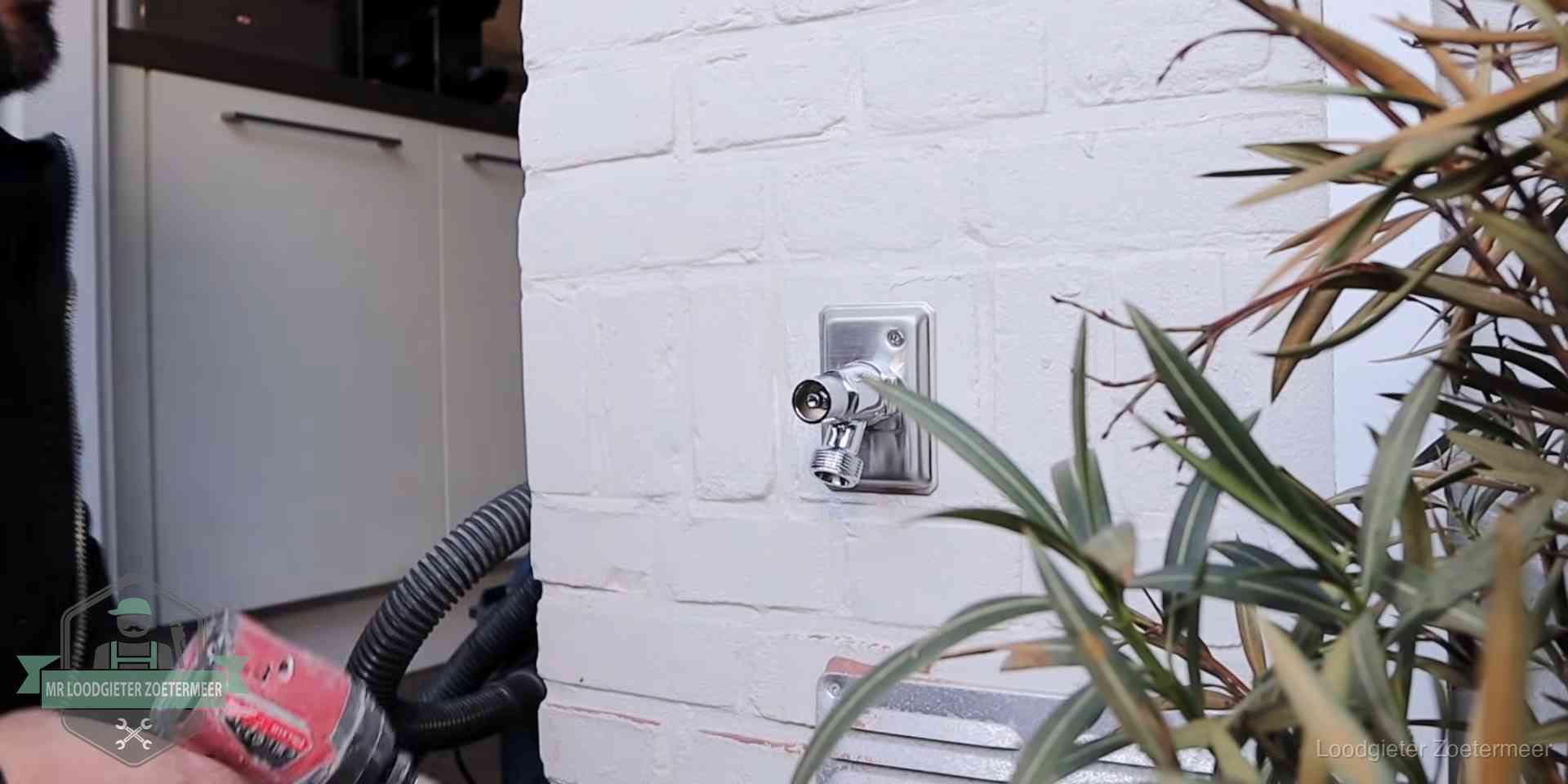 Chromen kraan op een muurplaat bij een woning in Zoetermeer, dichtdraaien is stap een van de lektest