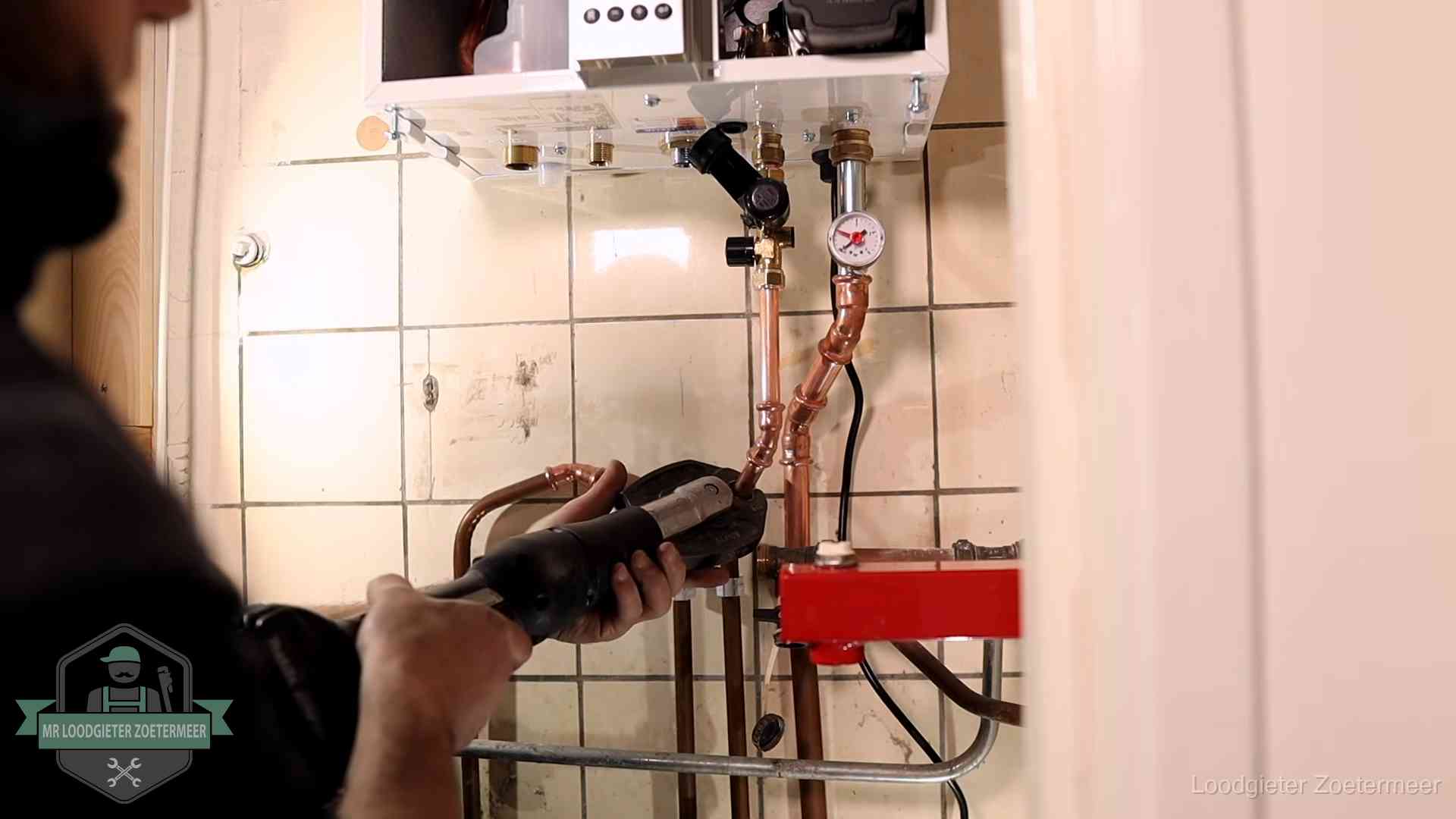 Cv-ketel onderhoud in Zoetermeer Monteur werkt aan de leidingen onder een cv-ketel in Zoetermeer
