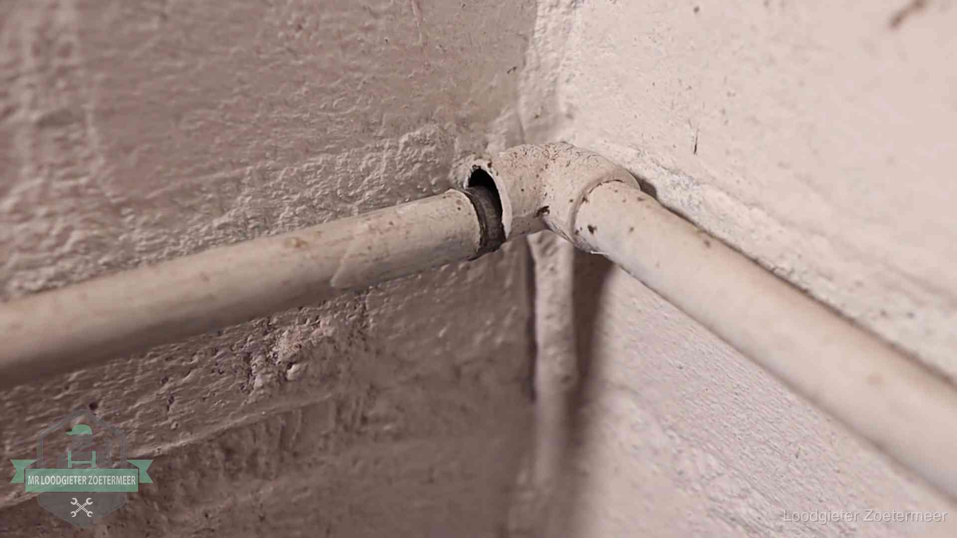 Oude waterleidingen en verborgen lekkage in Zoetermeer Oude geverfde waterleiding met een losliggende fitting in een woning in Zoetermeer