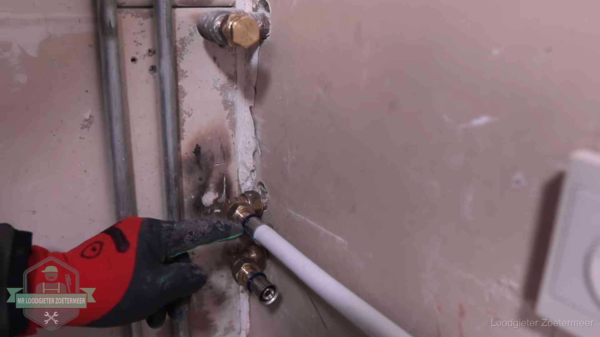 Loodgieter wijst de persfitting op nieuwe muuraansluitingen aan in een woning in Zoetermeer