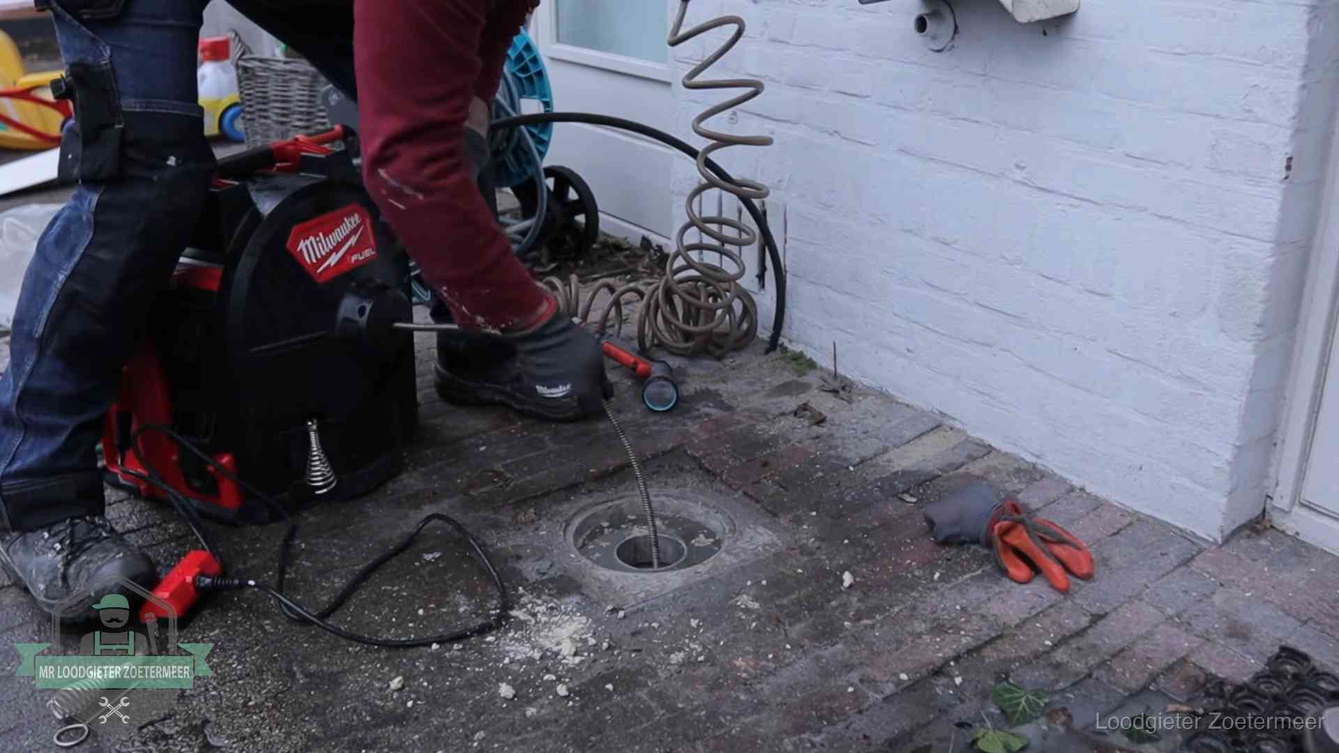 Spiraalmachine bij een ontstoppingsputje in de bestrating in Zoetermeer