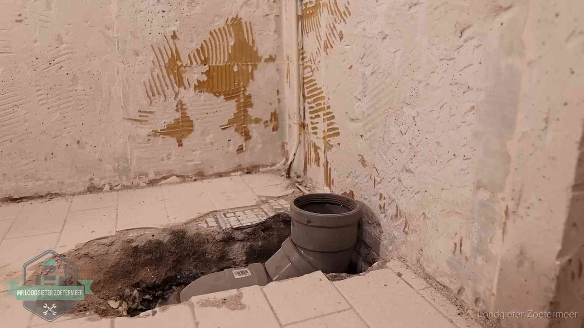 Opengebroken vloer met een nieuwe pvc-rioolbocht in een gegraven sleuf in Zoetermeer