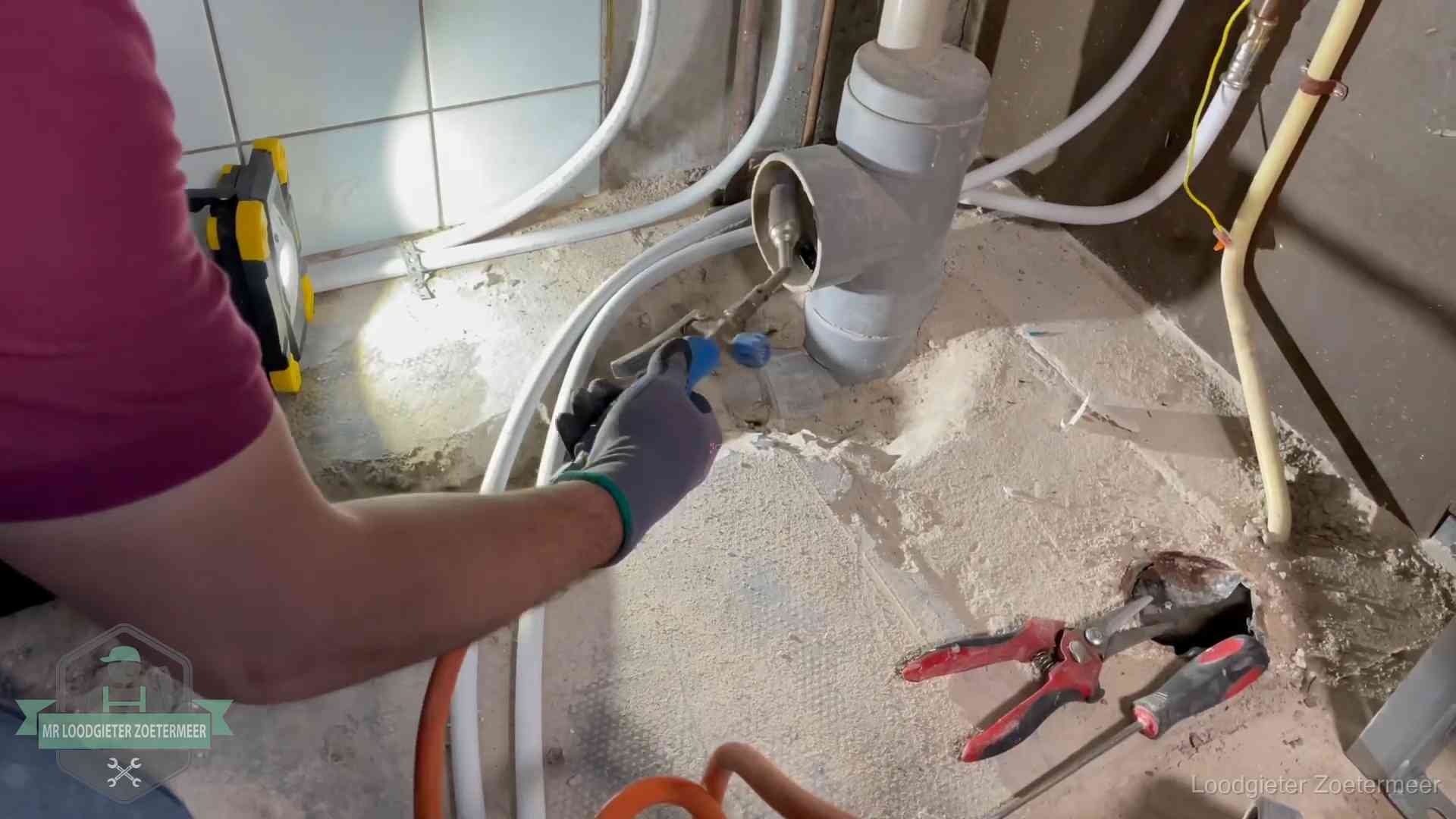 Loodgieter werkt aan leidingen bij een pvc-standleiding in een appartement in Zoetermeer