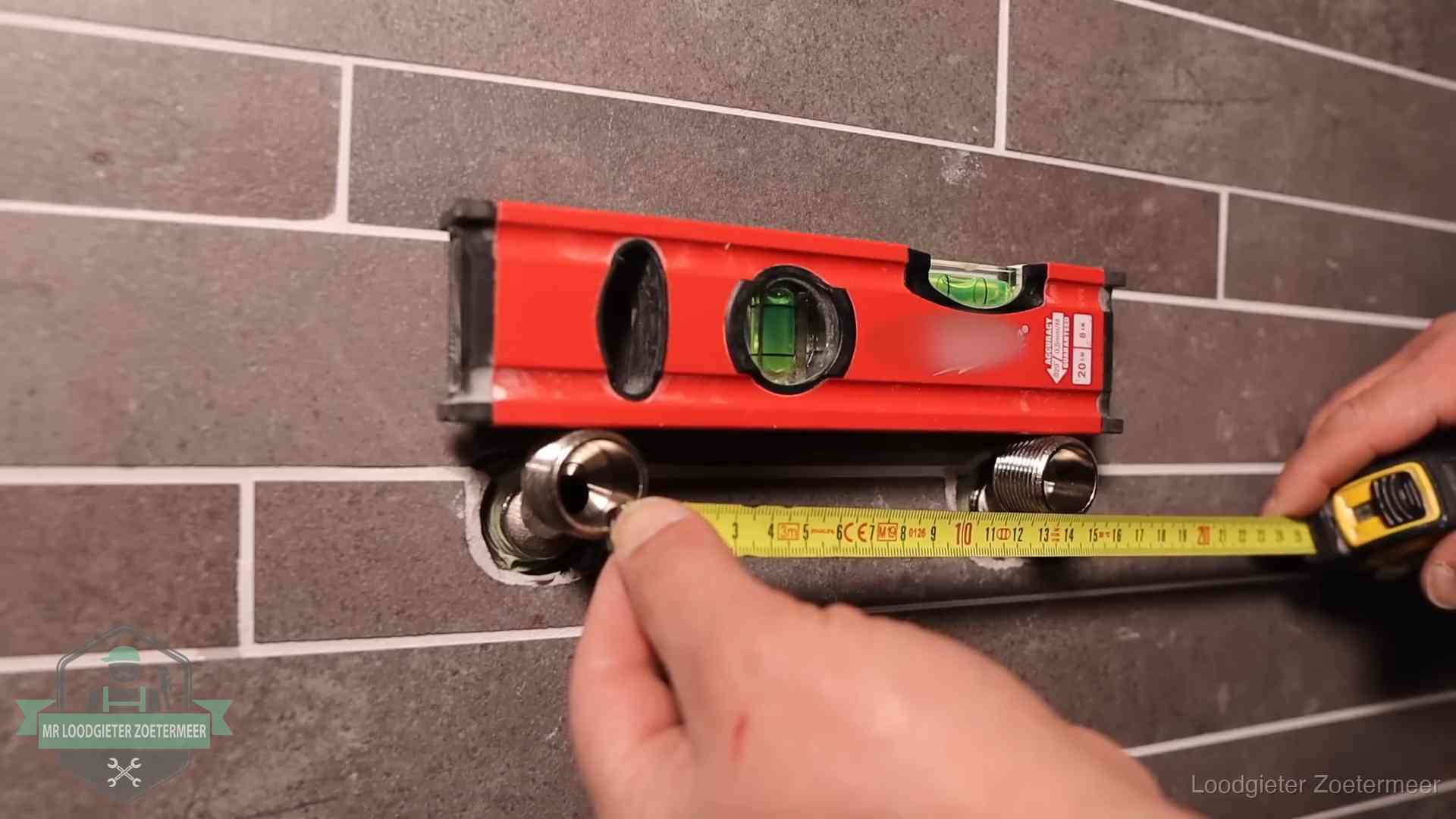 Waterpas en duimstok bij kraan-aansluitpunten in een badkamer in Zoetermeer
