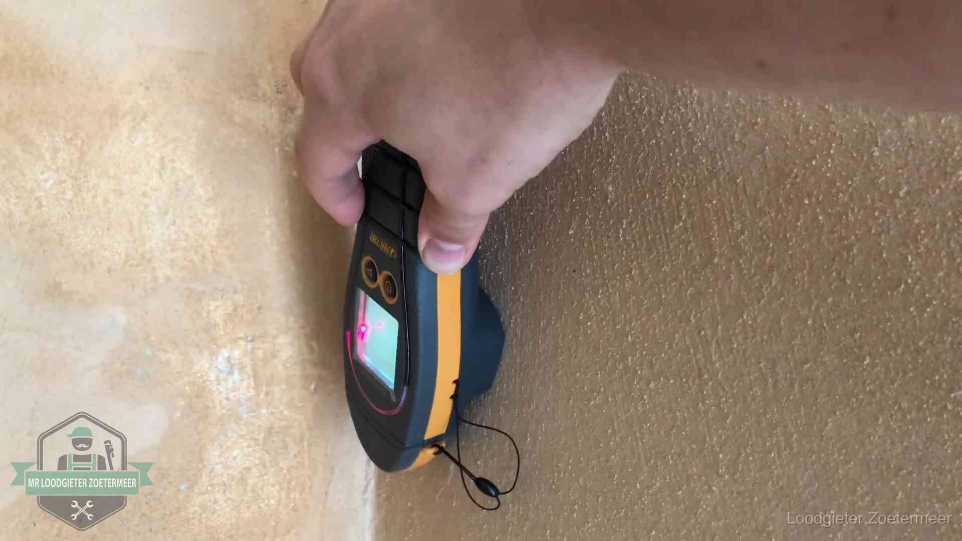 Vochtmeter tegen een muur met vochtplekken tijdens het opsporen van een daklekkage in Zoetermeer