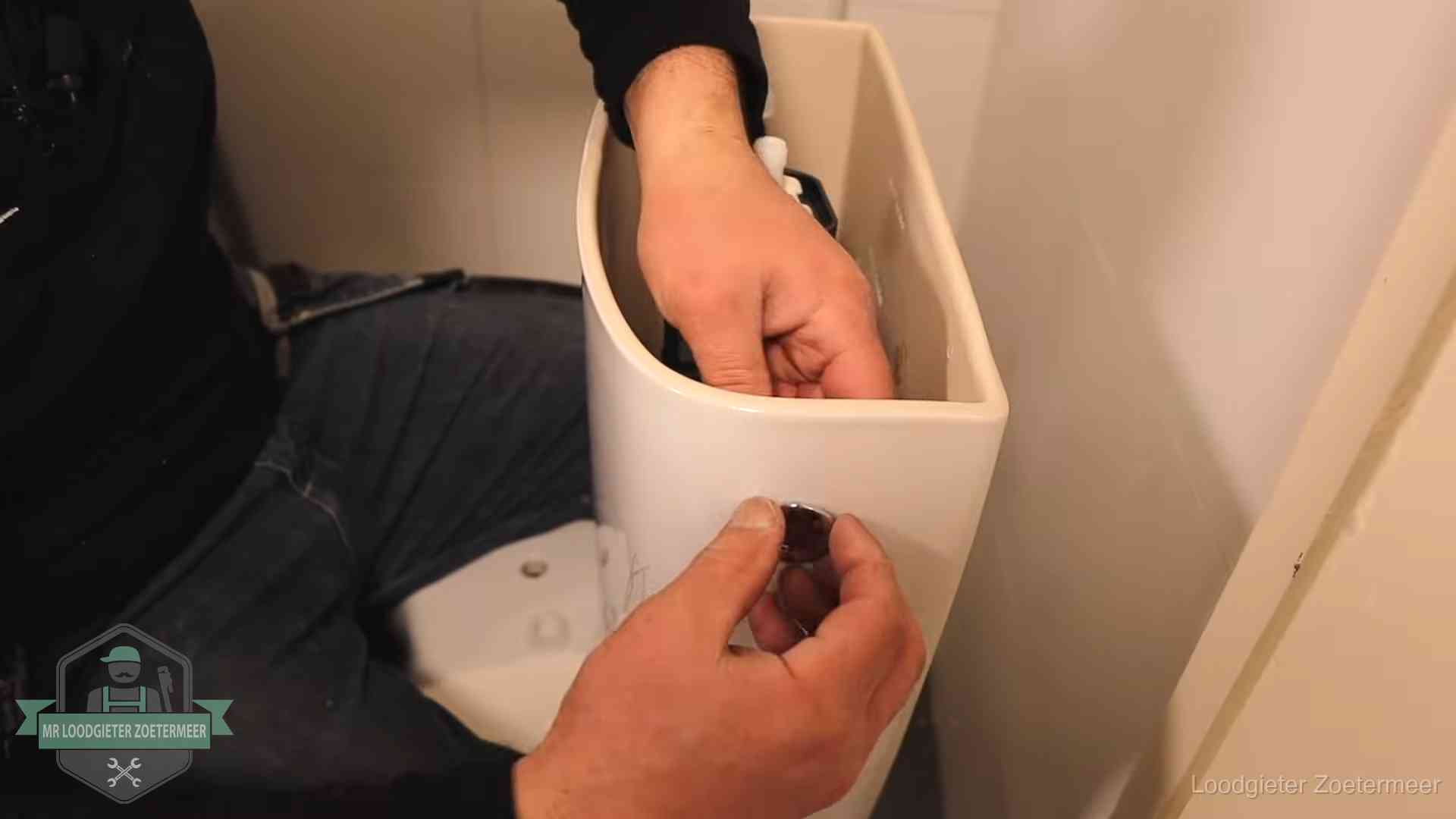 Je wc verstoppingsvrij houden in Zoetermeer Drukknop van een duoblok-stortbak wordt gemonteerd bij een toilet in Zoetermeer